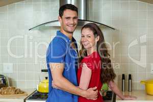 Happy couple embracing in kitchen