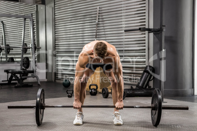 Shirtless man lifting barbell