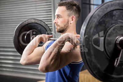 Muscular man ligting barbell