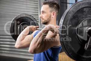 Muscular man ligting barbell