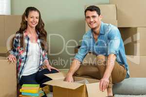 Young couple unpacking carton boxes in their new house