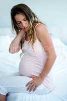 tired pregnant woman rubbing her neck