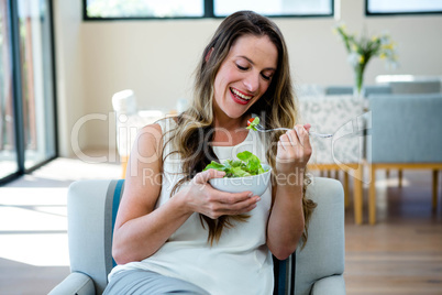 smiling woman eating a salad