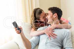 Young couple laughing while watching television