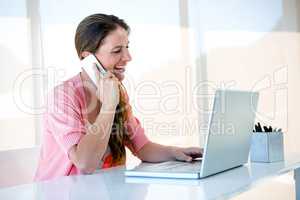 smiling woman on her laptop and smartphone