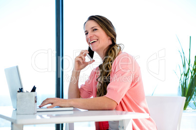 smiling woman on her laptop and smartphone
