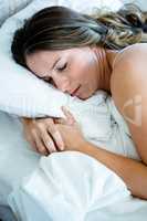 brunette woman asleep in her bed