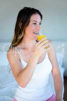 smiling woman driinking a glass of orange juice
