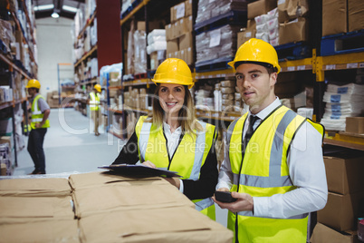 Warehouse managers looking at clipboard