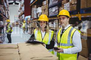 Warehouse managers looking at clipboard