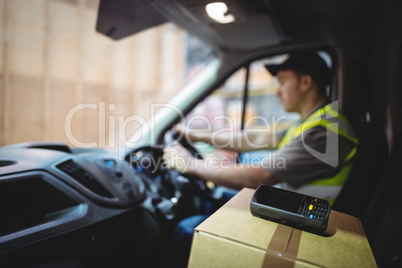 Delivery driver driving van with parcels on seat