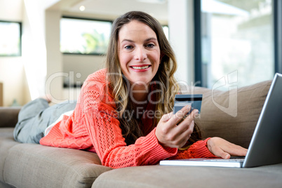 woman lying on the couch on her laptop