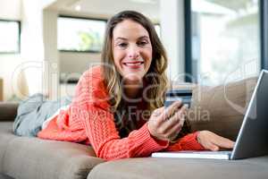 woman lying on the couch on her laptop