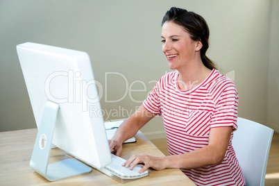 smiling woman typing on her laptop