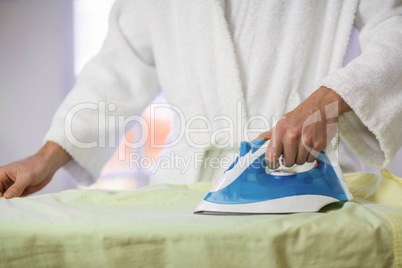 Close-up of man ironing a shirt