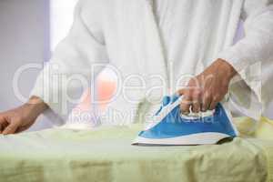 Close-up of man ironing a shirt