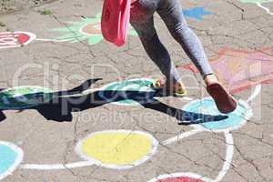 girl runs on the childish drawings on the asphalt