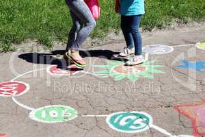 girls run on the childish drawings on the asphalt