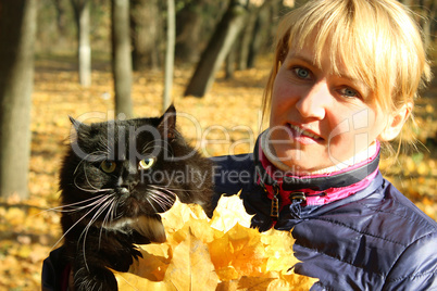 pretty modern woman with black cat in the park