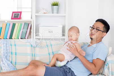 Exhausted father taking care baby alone