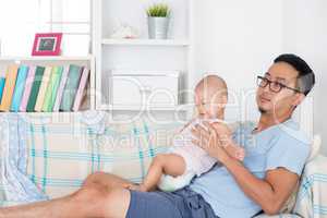 Exhausted father taking care baby alone