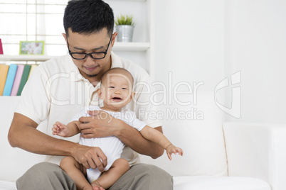 Asian father playing with baby boy