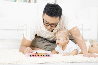 Father and baby playing music instrument.