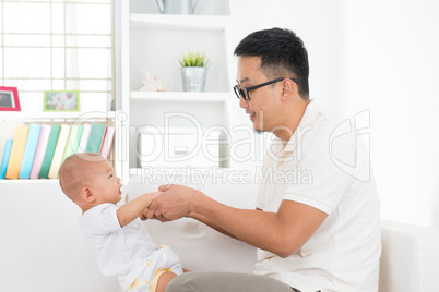 Asian father playing with baby