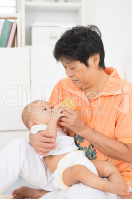 Grandmother bottle feeding baby
