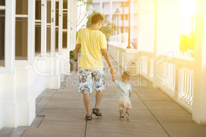 Father and child walking holding hands