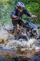 Quad rider through water stream