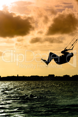 Silhouette of a kitesurfer flying