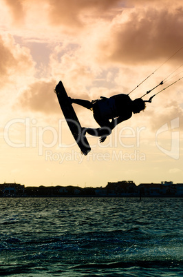 Silhouette of a kitesurfer flying