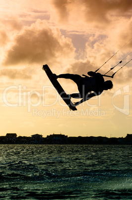 Silhouette of a kitesurfer flying