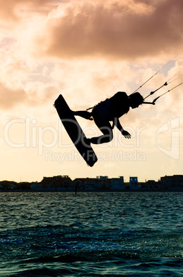 Silhouette of a kitesurfer flying