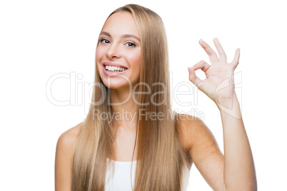 Young woman shows gesture ok on white background