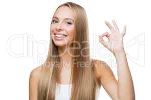 Young woman shows gesture ok on white background