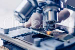 Scientist hands with microscope