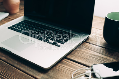 Workplace with open laptop on modern wooden desk