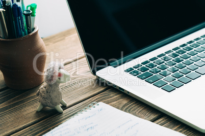 Workplace with open laptop on modern wooden desk