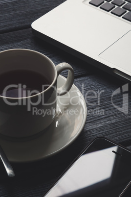 Office table with notepad, computer and tea cup