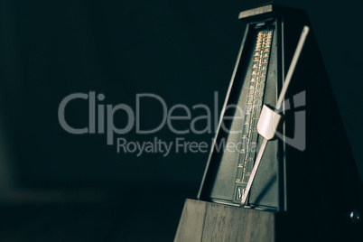 Vintage metronome, on a dark background.