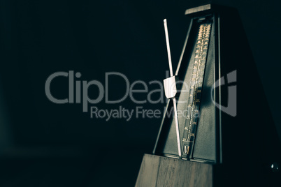 Vintage metronome, on a dark background.