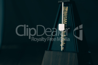 Vintage metronome, on a dark background.