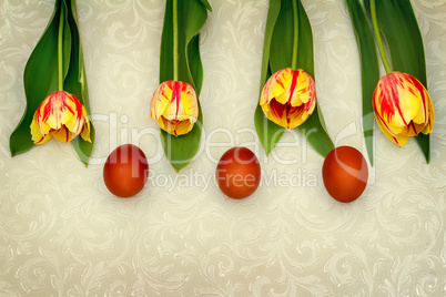 Three Easter eggs and tulips.