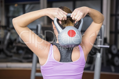 rear view of woman lifting kettlebell