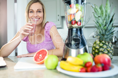 Pretty blonde woman drinking her homemade smoothie