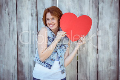 smiling hipster woman holding a carboard heart