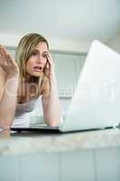 Pretty blonde woman looking at laptop
