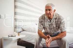 Senior man sitting on bed